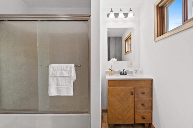 bathroom with a shower with door and vanity