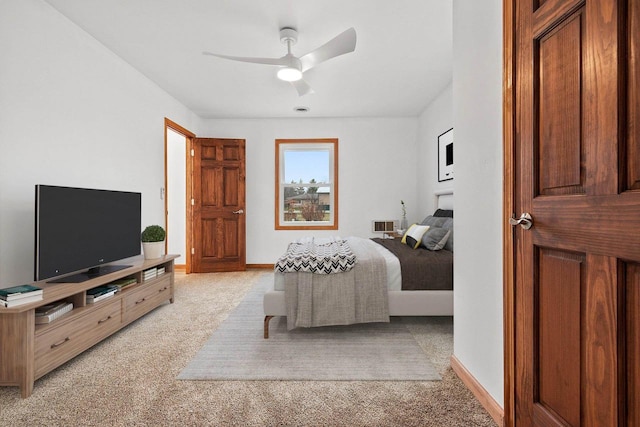 bedroom featuring ceiling fan, baseboards, and light colored carpet