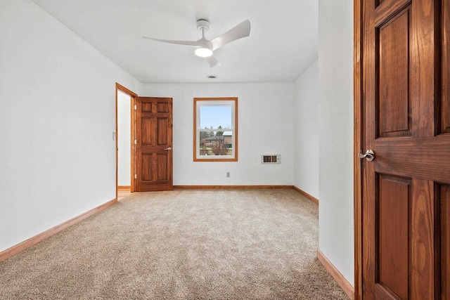 empty room with light colored carpet, ceiling fan, and baseboards