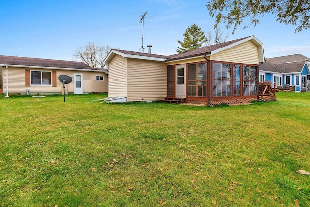 rear view of property featuring a sunroom and a yard