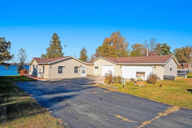 single story home featuring driveway, a front lawn, and an attached garage