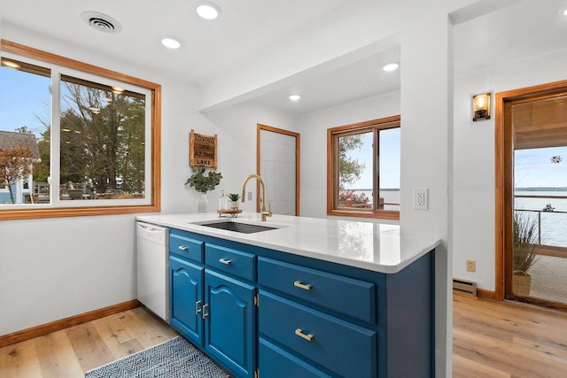 kitchen with visible vents, dishwasher, light wood-style flooring, blue cabinets, and a sink