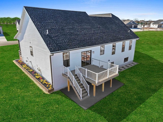 back of property featuring a shingled roof, stairway, a wooden deck, and a yard