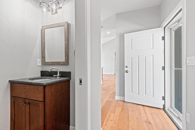 bathroom featuring wood finished floors, vanity, and baseboards