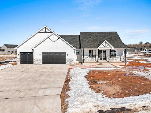 modern farmhouse style home featuring a garage, stone siding, board and batten siding, and concrete driveway