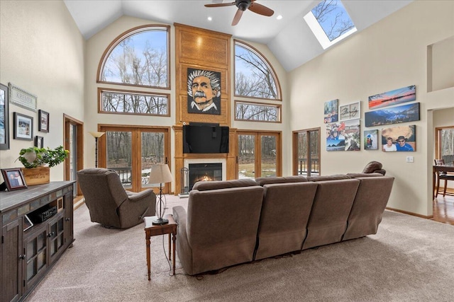 living area with light carpet, a fireplace, baseboards, and a wealth of natural light