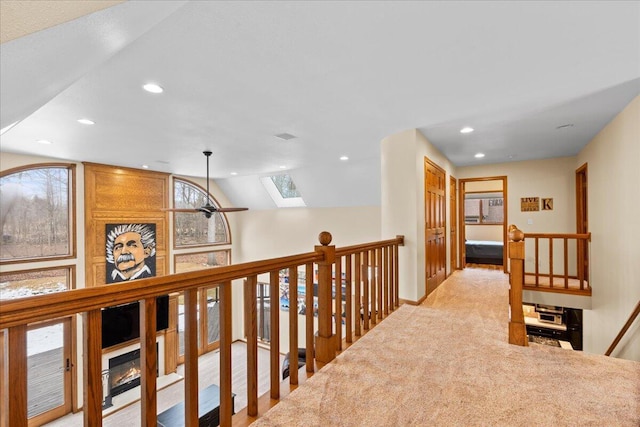 corridor with recessed lighting, baseboards, vaulted ceiling with skylight, and carpet