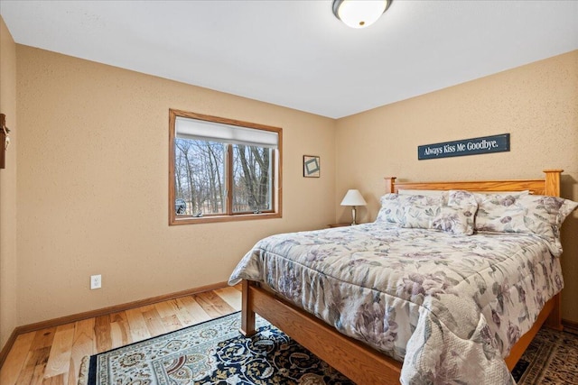 bedroom with baseboards and wood finished floors