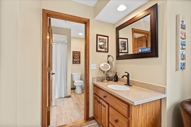 bathroom featuring recessed lighting, vanity, toilet, and wood finished floors