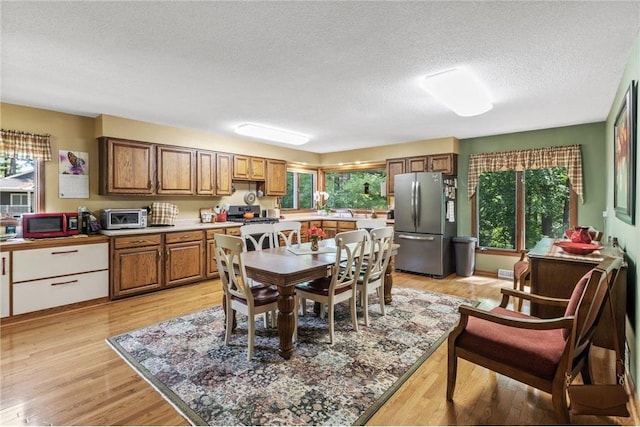 115 Pine Crest Rd, Balsam Lake, WI 54810 - kitchen with a textured ceiling, light wood-style flooring, a toaster, stainless steel appliances, and brown cabinets