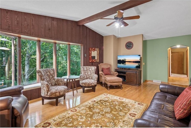115 Pine Crest Rd, Balsam Lake, WI 54810 - living area with arched walkways, vaulted ceiling with beams, visible vents, wooden walls, and wood finished floors