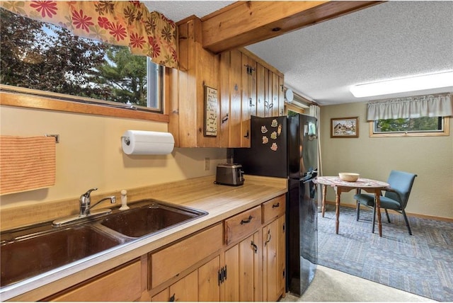 115 Pine Crest Rd, Balsam Lake, WI 54810 - kitchen with a textured ceiling, a sink, light countertops, freestanding refrigerator, and brown cabinetry