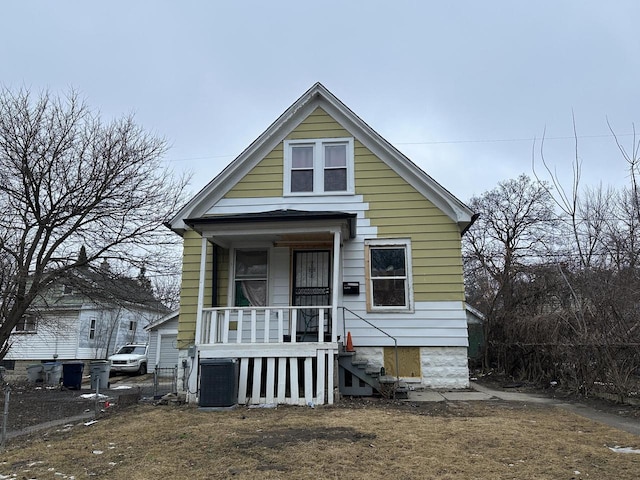 shotgun-style home featuring central AC unit and a porch