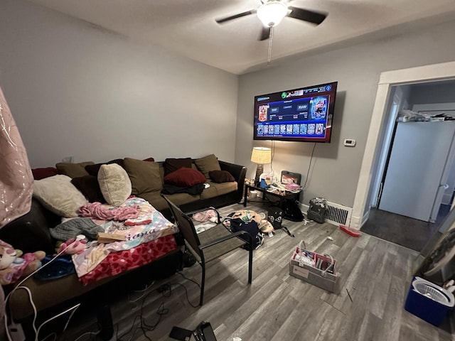 living room with ceiling fan, wood finished floors, and baseboards