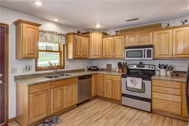 kitchen featuring stainless steel appliances, recessed lighting, visible vents, light wood-style flooring, and a sink