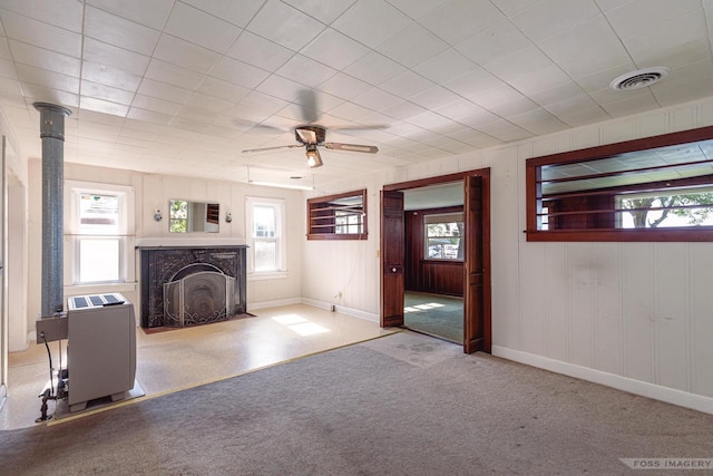 unfurnished living room with carpet, a healthy amount of sunlight, visible vents, and baseboards