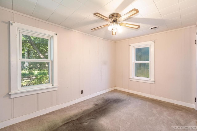 unfurnished room with plenty of natural light, visible vents, and a decorative wall