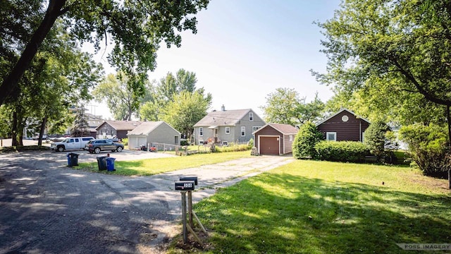 view of front of house featuring driveway, a residential view, a detached garage, an outdoor structure, and a front lawn