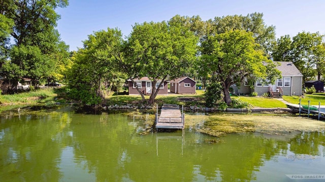 dock area with a water view and a yard