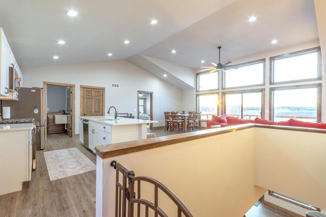 N8791 Lake Cabin Dr, New Lisbon, WI 53950 - kitchen featuring a center island with sink, white cabinets, light wood-style flooring, light countertops, and a sink