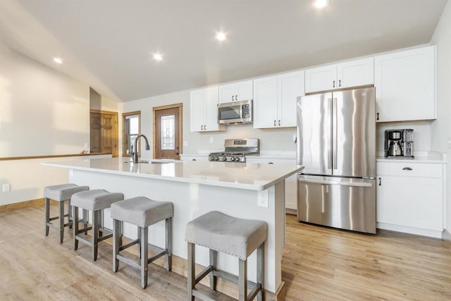 N8791 Lake Cabin Dr, New Lisbon, WI 53950 - kitchen with a center island with sink, stainless steel appliances, light wood-style flooring, white cabinets, and a sink