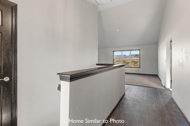 hall with lofted ceiling, dark wood-style flooring, an upstairs landing, and baseboards