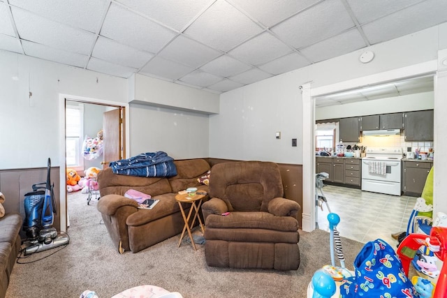 living area with light carpet and a drop ceiling