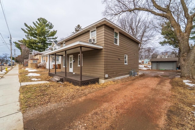 view of home's exterior featuring a porch, cooling unit, and an outdoor structure