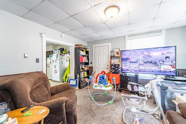 carpeted living area featuring a drop ceiling