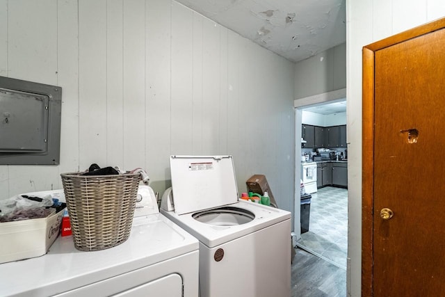 clothes washing area with laundry area, electric panel, and washer and dryer