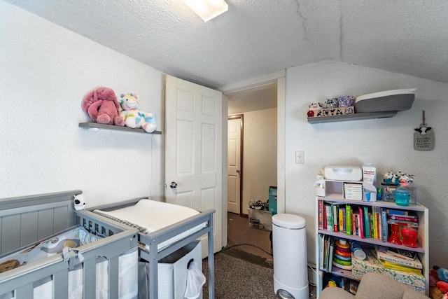 bedroom featuring lofted ceiling, carpet floors, and a textured ceiling