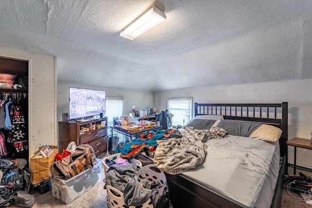 carpeted bedroom with vaulted ceiling and a textured ceiling