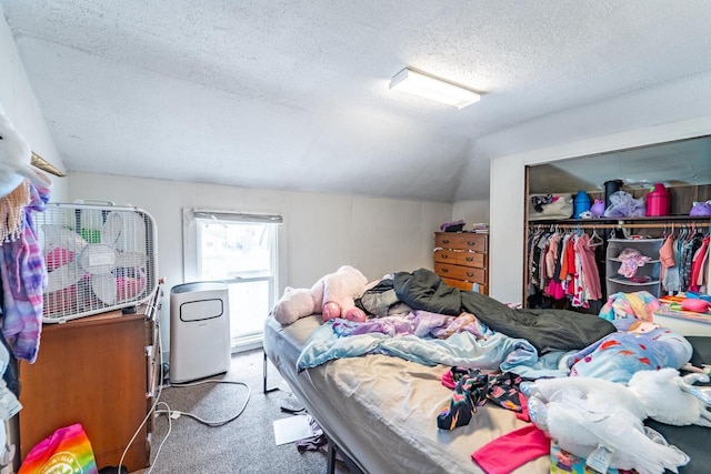 bedroom with lofted ceiling, a closet, carpet flooring, and a textured ceiling