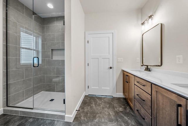 bathroom featuring double vanity, baseboards, marble finish floor, a shower stall, and a sink