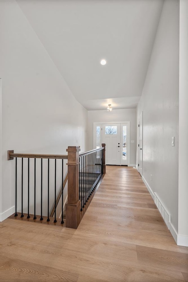 hall with recessed lighting, wood finished floors, visible vents, and baseboards