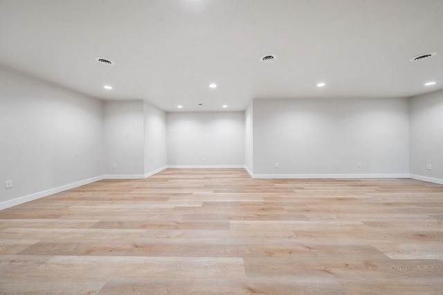 empty room featuring light wood finished floors, visible vents, baseboards, and recessed lighting