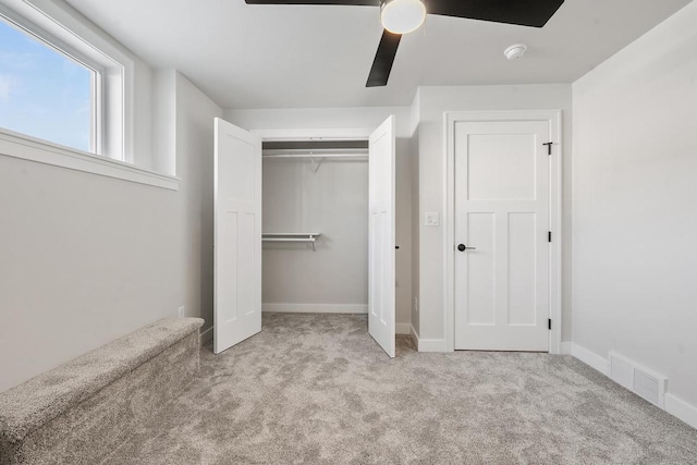 unfurnished bedroom with baseboards, visible vents, a ceiling fan, carpet floors, and a closet