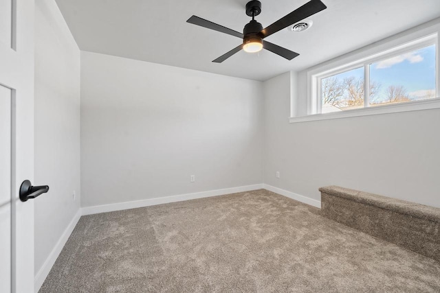 empty room featuring carpet floors, visible vents, stairway, a ceiling fan, and baseboards