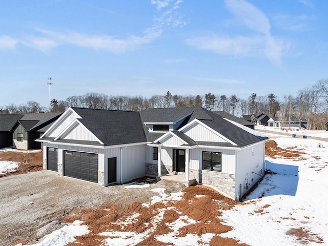 modern inspired farmhouse featuring stone siding, roof with shingles, and an attached garage