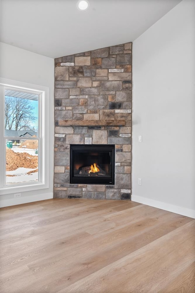 interior details featuring a fireplace, baseboards, and wood finished floors