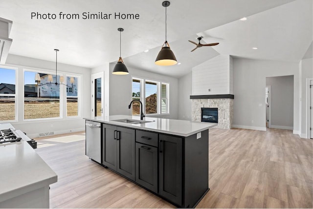 kitchen featuring visible vents, light wood-style flooring, light countertops, stainless steel dishwasher, and a sink