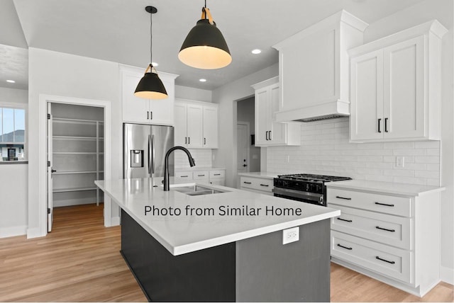 kitchen featuring light wood-type flooring, gas range, a sink, and stainless steel fridge with ice dispenser