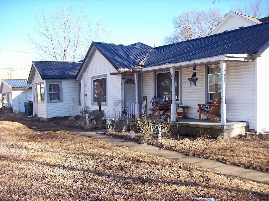 ranch-style home with metal roof and a porch