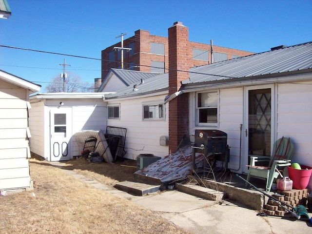 1002 Adams St, Portage, WI 53901 - back of house featuring metal roof and a chimney