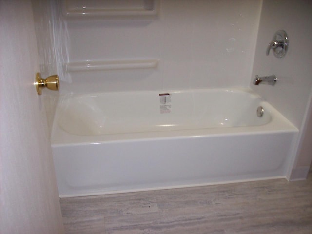 1002 Adams St, Portage, WI 53901 - full bathroom featuring a tub to relax in and wood finished floors