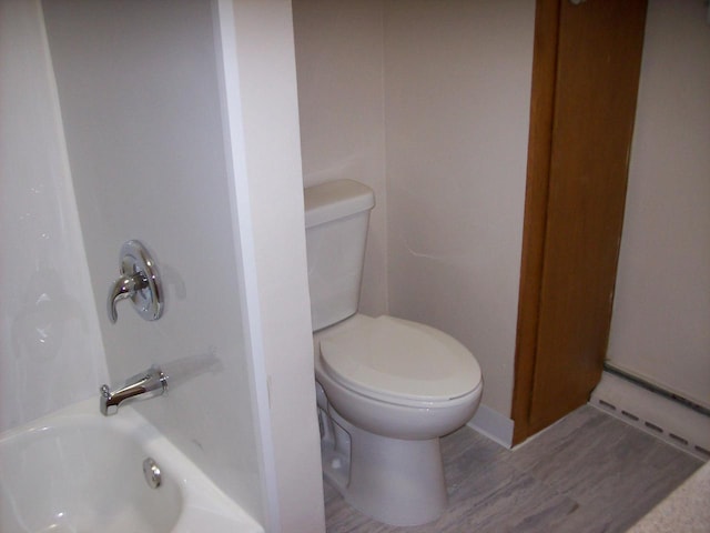 1002 Adams St, Portage, WI 53901 - full bath with wood finished floors, toilet, and washtub / shower combination