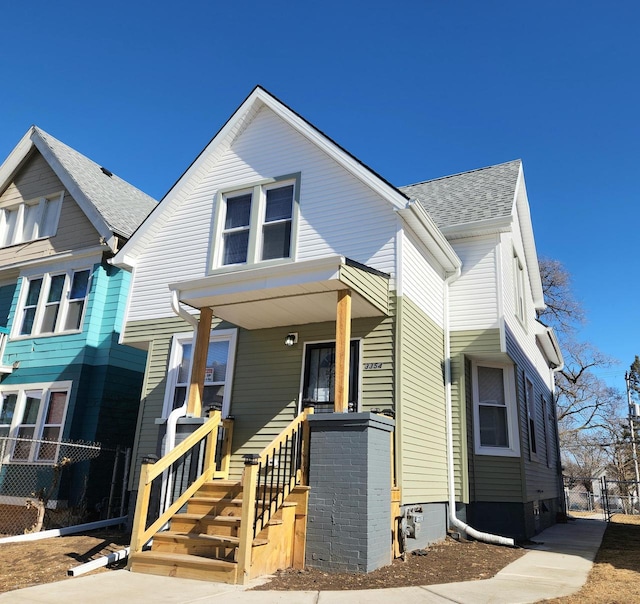 view of front of property with fence and roof with shingles