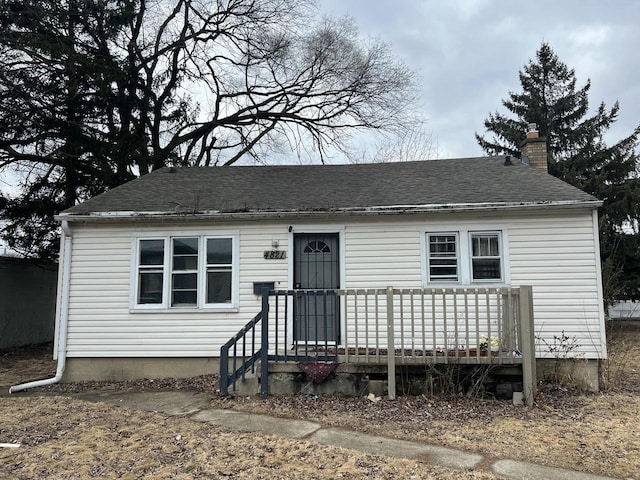 view of front of house featuring a chimney and roof with shingles