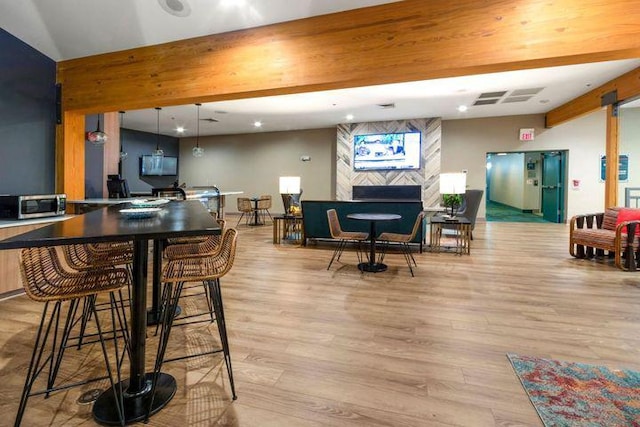 interior space featuring stainless steel microwave, wood finished floors, beamed ceiling, a fireplace, and recessed lighting