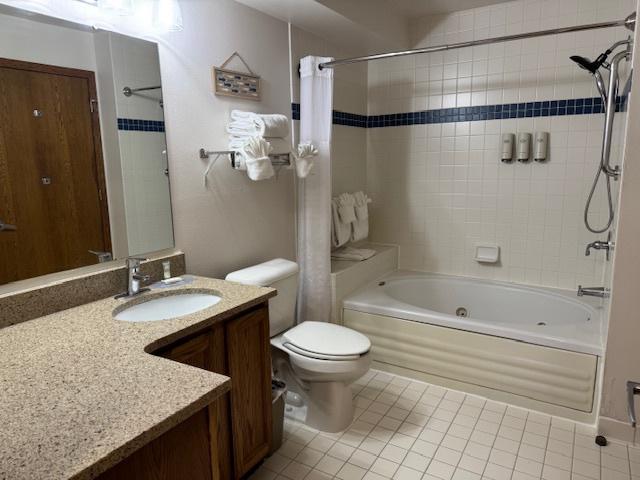 full bathroom featuring vanity, shower / bath combination with curtain, toilet, and tile patterned floors